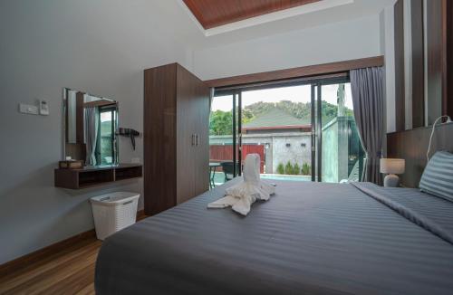 a bedroom with a large bed and a large window at N&D Poolvilla in Ao Nang Beach