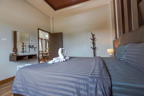 a bedroom with a large bed with a blue blanket at N&D Poolvilla in Ao Nang Beach