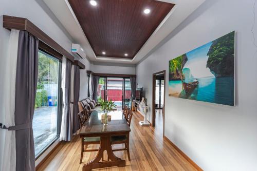a dining room with a table and a large painting on the wall at N&D Poolvilla in Ao Nang Beach