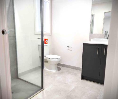 a bathroom with a shower and a toilet and a sink at Lucas One 2-bedroom apartment NBN Pets in Windermere