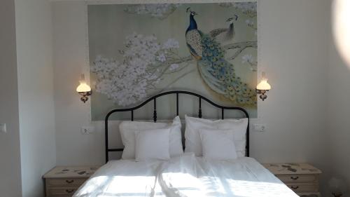 1 dormitorio con 1 cama con una pintura de pavo real en la pared en Villa Franzen en Derenbach