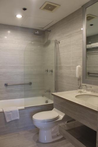 a bathroom with a toilet and a shower and a sink at Vivere Hotel and Resorts in Manila