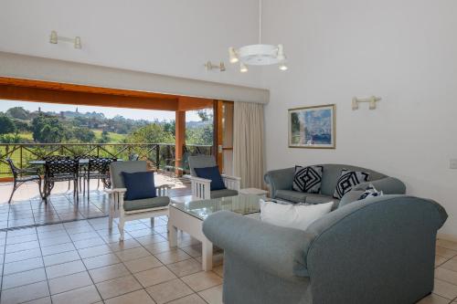 a living room with couches and a table and a balcony at San Lameer Villa 10312 - 3 Bedroom Standard - 6 pax - San Lameer Rental Agency in Southbroom