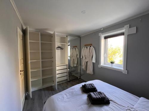 a bedroom with a bed and a window and shelves at Vestre Haugen House Sentralt OSLO Gratis privat parkering in Høybråten