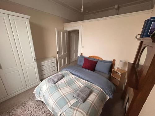 um quarto com uma cama com almofadas azuis e vermelhas em A sunny flat near town centre em Brighton & Hove