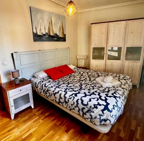 een slaapkamer met een bed en een tafel met een nachtkastje bij Balcón con Vistas a la Catedral de Burgos- ATUAIRE- in Burgos
