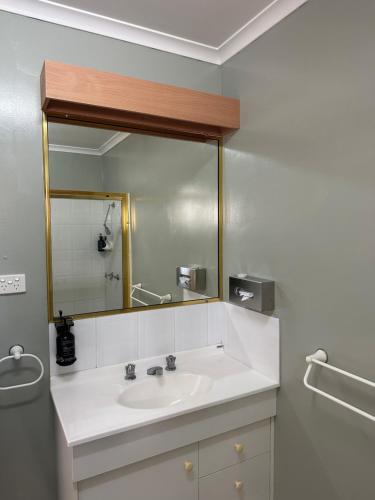a bathroom with a sink and a large mirror at Murgon Motor Inn in Murgon