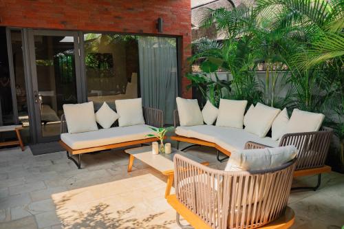 eine Terrasse mit Sofas, einem Tisch und Stühlen in der Unterkunft Flowering Villa in Xiaoliuqiu
