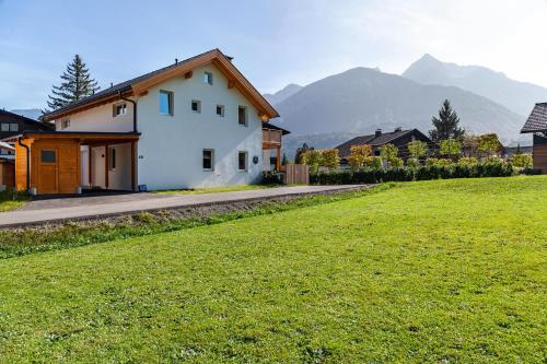 a house in a field with mountains in the background at Bubbelen aan de piste in Kötschach