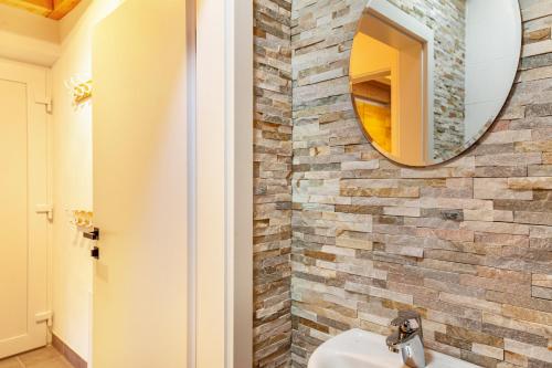 a bathroom with a stone wall and a mirror at Bubbelen aan de piste in Kötschach