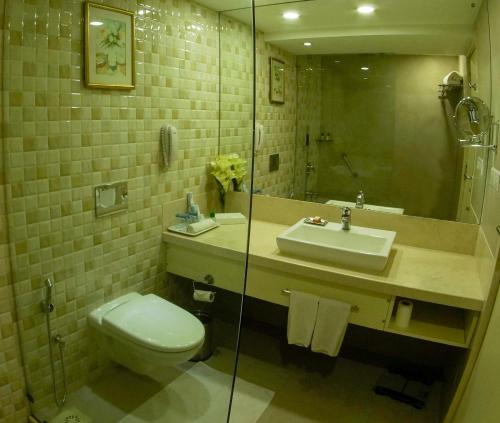 a bathroom with a toilet and a sink and a mirror at Fortune Park Galaxy, Vapi - Member ITC Hotels' Group in Vapi