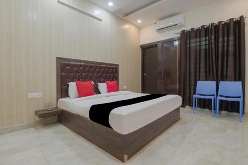 a bedroom with a large bed and two blue chairs at Hotel Valley Wood Inn in Rājpur