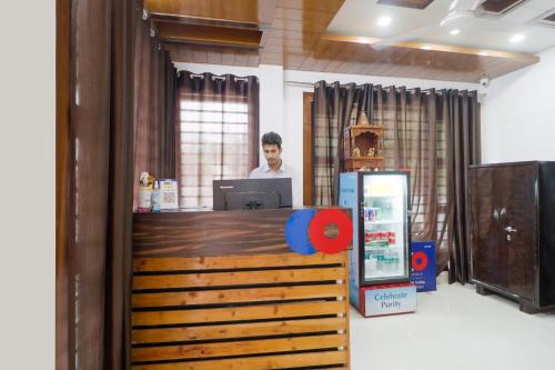 a man is standing at a counter in a office at Hotel Valley Wood Inn in Rājpur