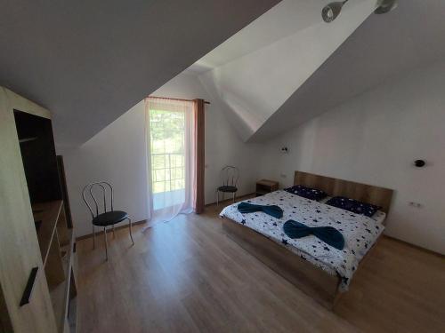 a bedroom with a bed and a large window at Casa Varipatti in Buşteni