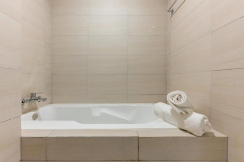 a white bath tub in a bathroom with a towel at Axis Residence by Caerus Management in Phnom Penh