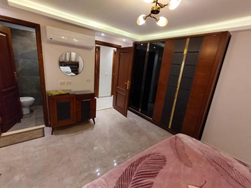 een slaapkamer met een badkamer met een wastafel en een spiegel bij شقة مستوى فندقى المهندسين للعائلات فقط in Caïro
