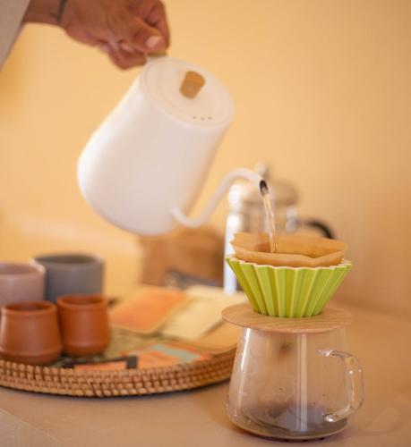 a person is pouring coffee into a cupcake at Casa Solana in Patong Beach