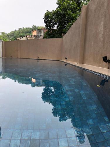 a swimming pool with a reflection in the water at Hotel Bamiyan in Kandy