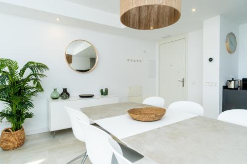 EsteponaAL-1112 2 Bed Alcazaba Lagoon的一间有桌子、椅子和镜子的餐厅