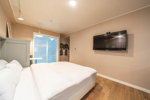 a bedroom with a white bed and a flat screen tv at HOTEL STAY AYANA DAEJEON in Daejeon