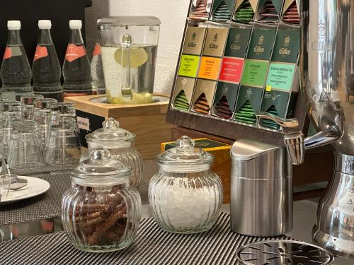 a table topped with glass jars and bottles of food at Tryp by Wyndham Rosenheim in Rosenheim