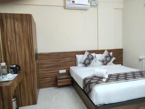 1 dormitorio con 1 cama y pared de madera en Hotel Bulande Comforts-1 Bedroom Flat en Bangalore