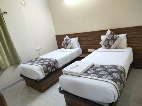 two beds in a hotel room with at Hotel Bulande Comforts 1 Bhk Flat Manyata Tech Park in Bengaluru