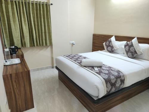 a bedroom with a bed with white sheets and a window at Hotel Bulande Comforts 1 Bhk Flat Manyata Tech Park in Bengaluru