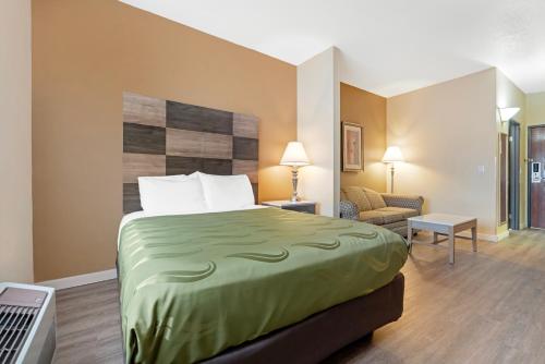 a hotel room with a bed and a living room at Quality Inn Bemidji in Bemidji