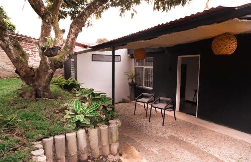 a porch of a house with chairs and a tree at DeRequka Hostel in Pereira