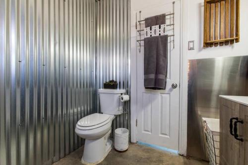 a bathroom with a white toilet and a sink at JT's Star Catcher Cabin - HOT TUB in Yucca Valley
