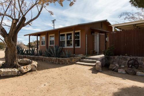 a house with a tree in front of it at JT's Star Catcher Cabin - HOT TUB in Yucca Valley