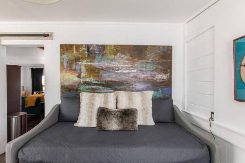 a bedroom with a bed with a painting on the wall at JT's Star Catcher Cabin - HOT TUB in Yucca Valley