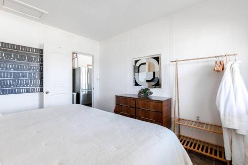 a white bedroom with a bed and a mirror at JT's Star Catcher Cabin - HOT TUB in Yucca Valley