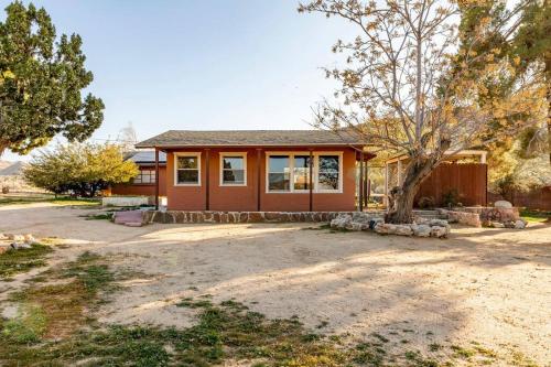 a house with a tree in front of it at JT's Star Catcher Cabin - HOT TUB in Yucca Valley