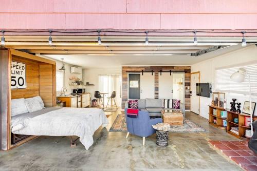 a bedroom with a bed and a couch in a room at JT's Star Catcher Cabin - HOT TUB in Yucca Valley