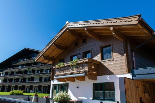 a house with a balcony in front of a building at Weinzeit Chalet in Königsleiten