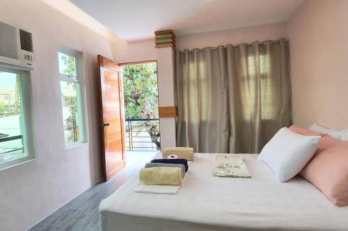 sypialnia z dużym białym łóżkiem i oknem w obiekcie 2 Houses w/ parking for best guest w mieście Iloilo