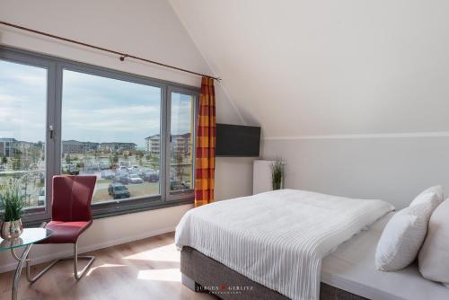 ハイリゲンハーフェンにあるOstsee - Reetdachhaus Nr 8 "Sonne und mehr" im Strand Resortのベッドルーム1室(ベッド1台、大きな窓付)