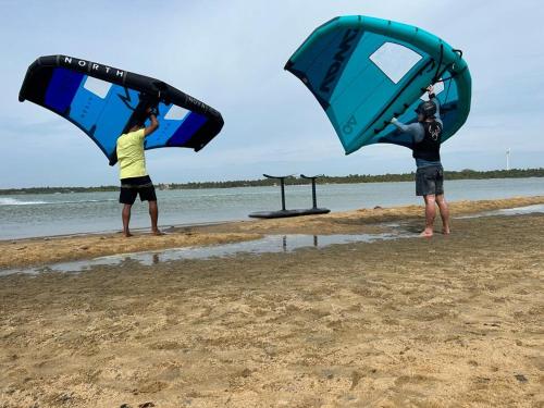 two people standing on the beach holding their kites at De Silva Palm Resort in Kalpitiya