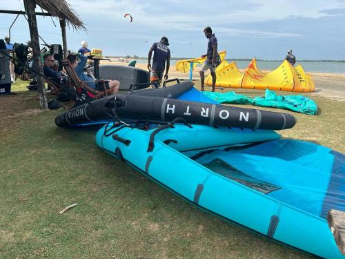 a group of people on the beach with a blue kayak at De Silva Palm Resort in Kalpitiya