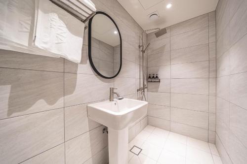 a white bathroom with a sink and a mirror at HOTEL STAY AYANA DAEJEON in Daejeon