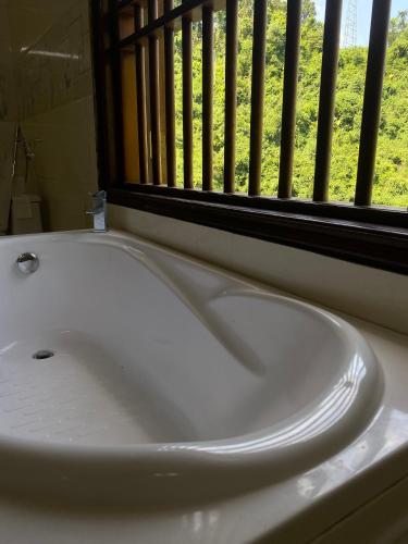 a white sink in a bathroom with a window at Wind's House Ha Giang in Ha Giang