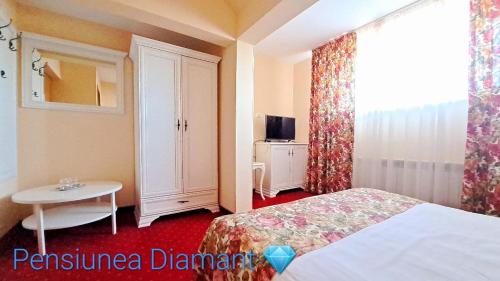 a bedroom with a bed and a table and a window at Pensiunea Diamant in Ghimbav
