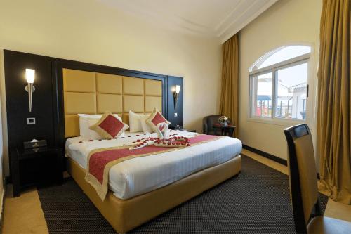 a hotel room with a large bed and a window at Royal Beach Hotel & Resort in Dibba