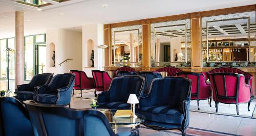a waiting room with chairs and a bar at Victor's Residenz-Hotel Schloss Berg in Nennig