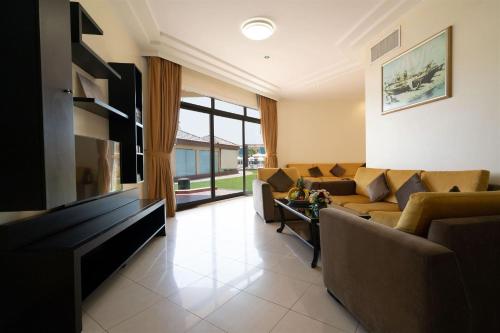 a living room with a couch and a tv at Royal Beach Hotel & Resort in Dibba