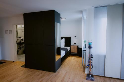 a bedroom with a bed and a black cabinet at KOCAK - Exklusives Apartment in Zentrumsnähe in Reutlingen