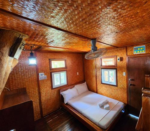 um pequeno quarto com uma cama numa casa em Uno Dus Tourist Inn em Itaytay