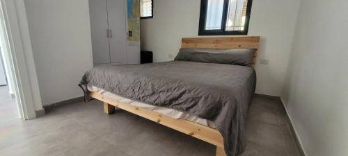 a bedroom with a wooden bed in a room at Newly Renovated Home in Bet Shemesh Vatika in Beit Shemesh